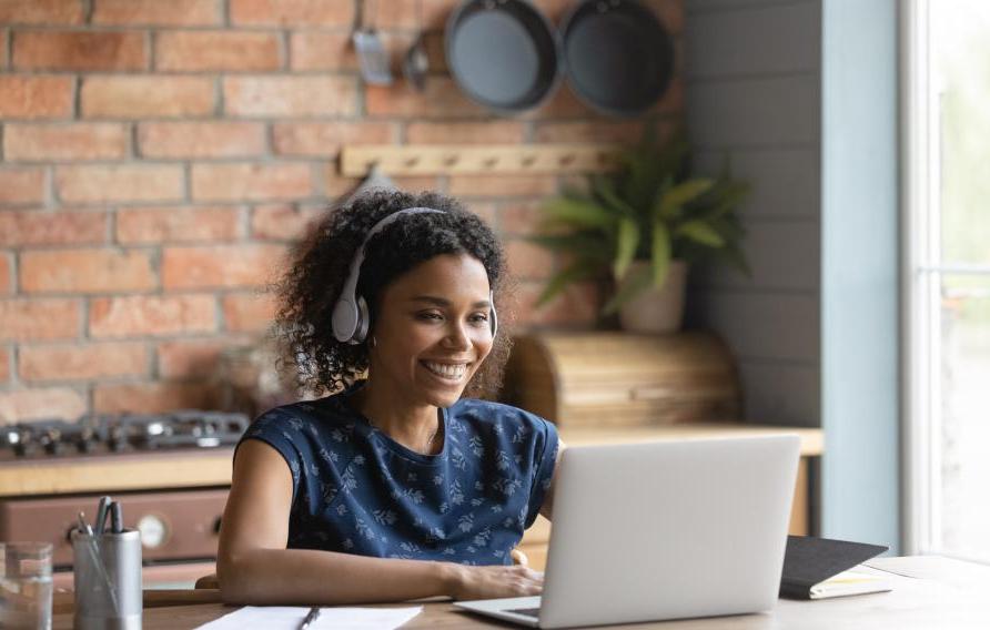 young female with headphones and laptop